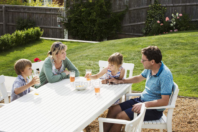 Familie sitzt am Gartentisch — Stockfoto