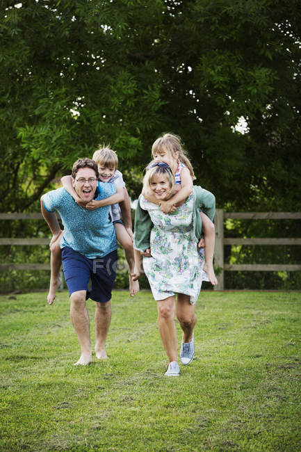 Man and woman running across a lawn — Stock Photo