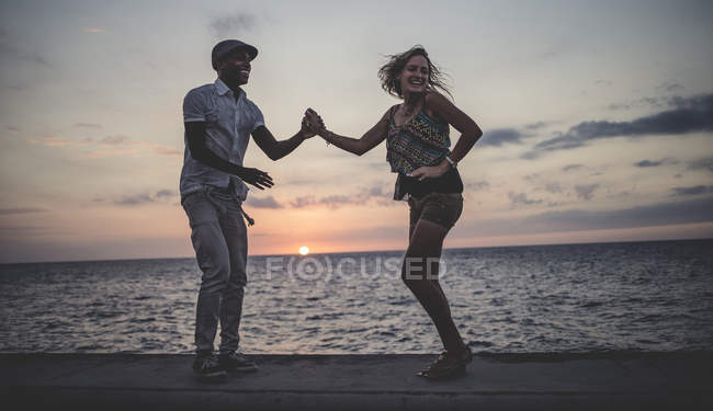 Paar tanzt in der Abenddämmerung am Meer. — Stockfoto