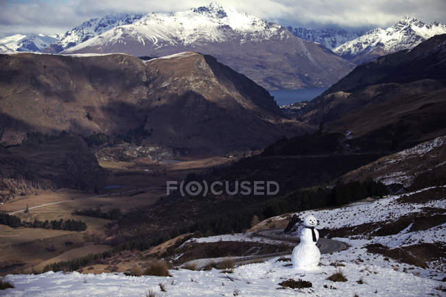 Valle de montaña con muñeco de nieve - foto de stock