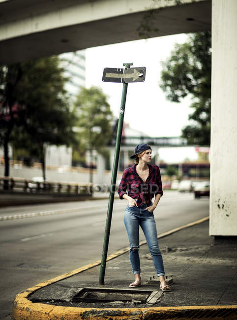 Woman standing at road junction — Stock Photo