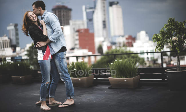 Couple hugging on city rooftop — Stock Photo