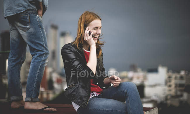Mujer sentada y hablando en el teléfono móvil - foto de stock