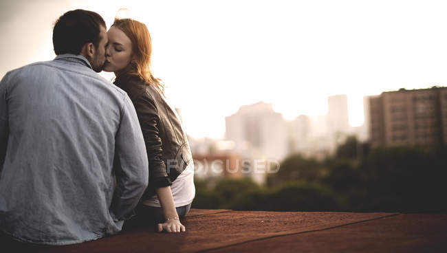 Пара сидя и целуясь — стоковое фото