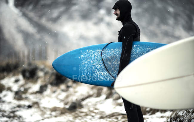 Surfer carrying surfboard — Stock Photo