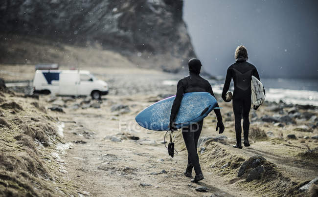 Surfers carrying surfboards — Stock Photo