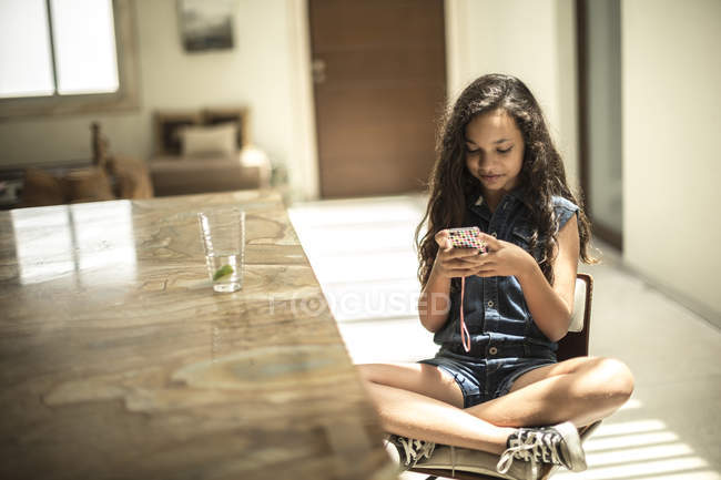 Девушка, сидящая, глядя на мобильный телефон — стоковое фото