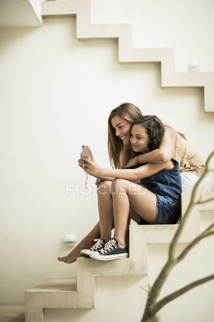 Frau und Mädchen sitzen auf Außentreppen — Stockfoto