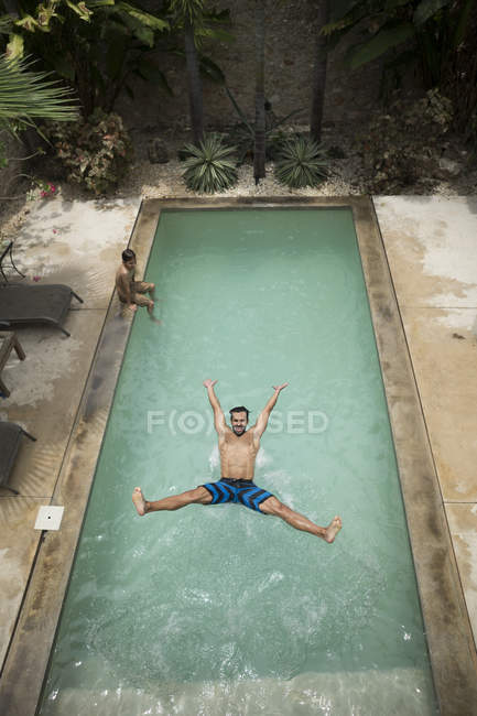 Hombre saltando en la piscina. - foto de stock
