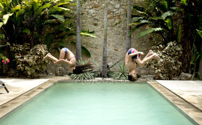 Niños saltando a la piscina . - foto de stock