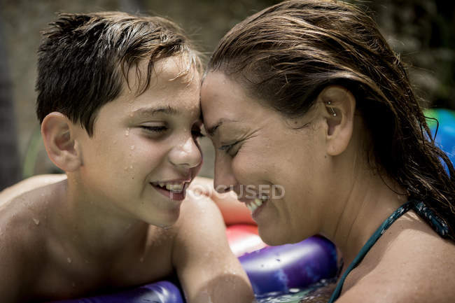Frau und Junge kuscheln im Schwimmbad. — Stockfoto