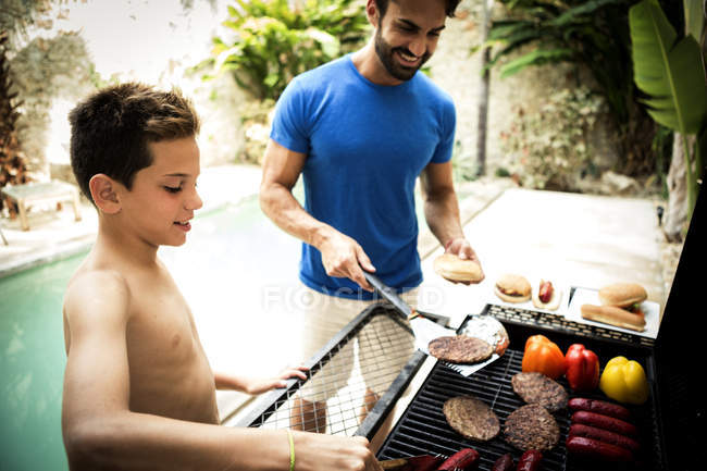 Uomo e ragazzo in piedi al barbecue — Foto stock