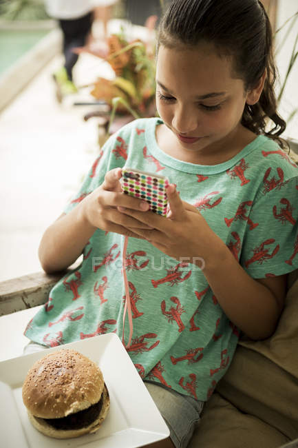 Девушка смотрит на мобильный телефон. — стоковое фото