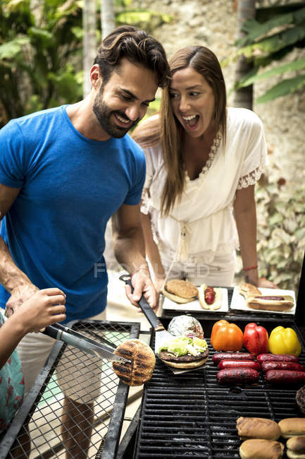 Couple standing at barbecue — Stock Photo