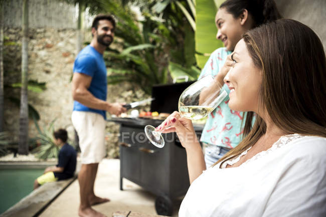Family near barbecue by swimming pool. — Stock Photo