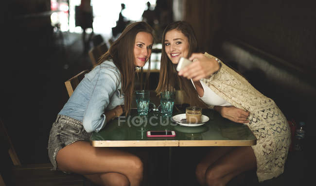 Jeunes femmes assises au café — Photo de stock