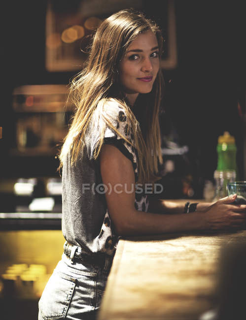 Молодая женщина, стоящая в баре — стоковое фото