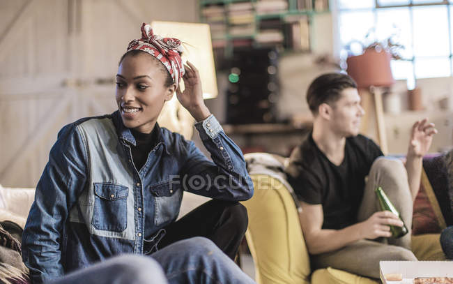 Женщина и мужчина сидят в помещении, улыбаясь . — стоковое фото