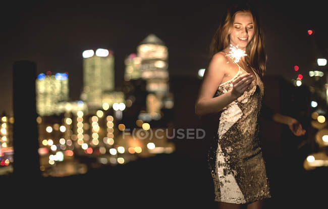 Mujer joven en vestido de fiesta de lentejuelas - foto de stock