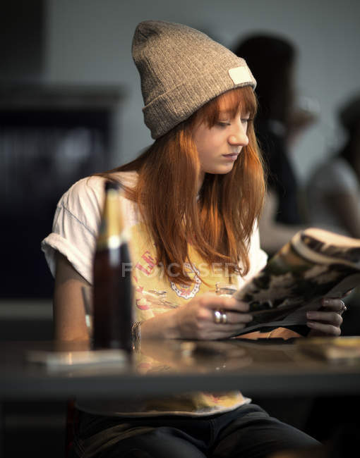 Young woman sitting at table — Stock Photo