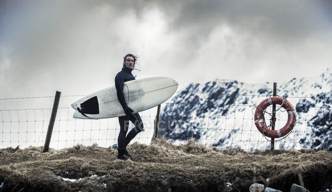 Surfista che trasporta tavola da surf — Foto stock