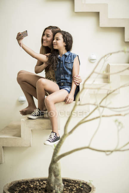 Жінка і дівчина сидять на відкритих сходах — стокове фото