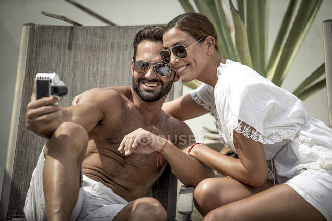 Couple sitting on sun loungers — Stock Photo