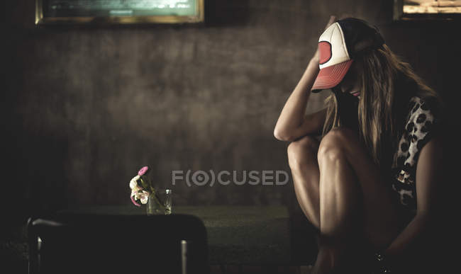 Молодая женщина сидит за маленьким столом — стоковое фото