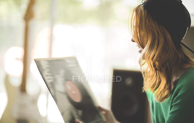 Woman looking at record sleeve. — Stock Photo