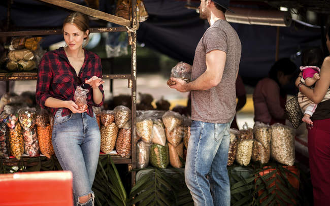 Couple faisant du shopping dans un étal de marché — Photo de stock