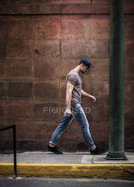 Homem andando ao longo da calçada — Fotografia de Stock