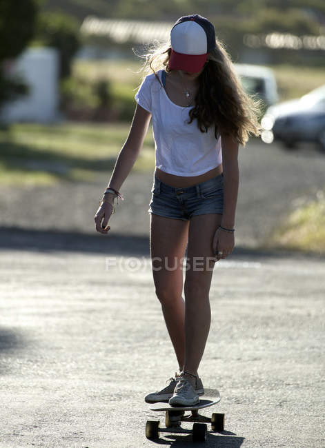 Jeune femme chevauchant sur skateboard — Photo de stock