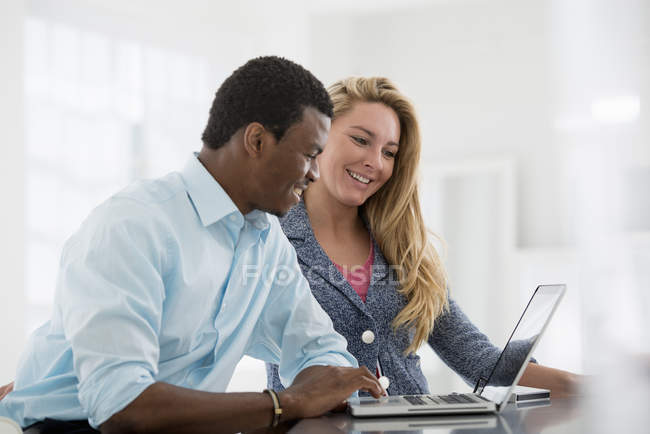 Coworkers sitting at table using laptop — Stock Photo