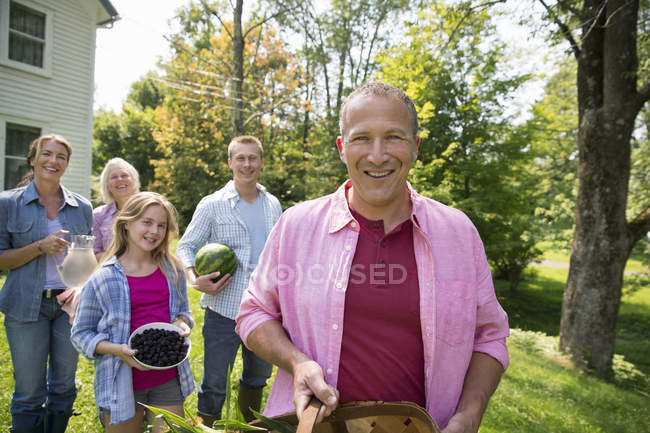 Vista cortada da família no quintal com produtos recém-colhidos — Fotografia de Stock