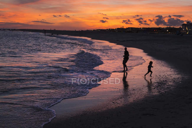 Батько і син, граючи на пляжі — стокове фото