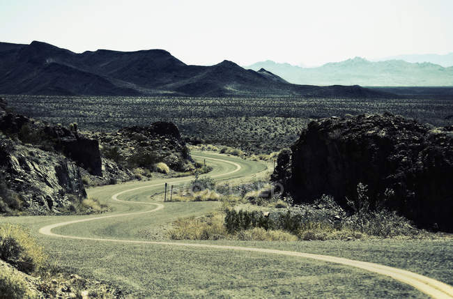 Carretera serpenteando a través del valle en paisaje de montaña . - foto de stock
