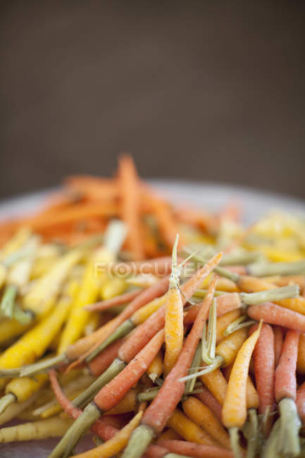 Gekochte orangefarbene, gelbe und rosafarbene Karotten. — Stockfoto