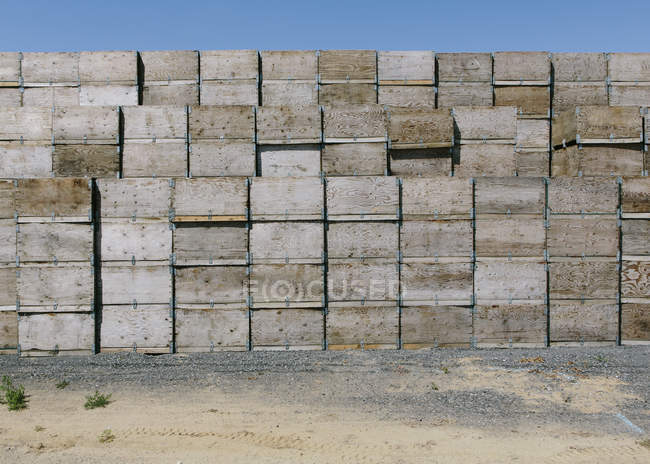 Large stack of wooden boxes stacked in countryside. — Stock Photo