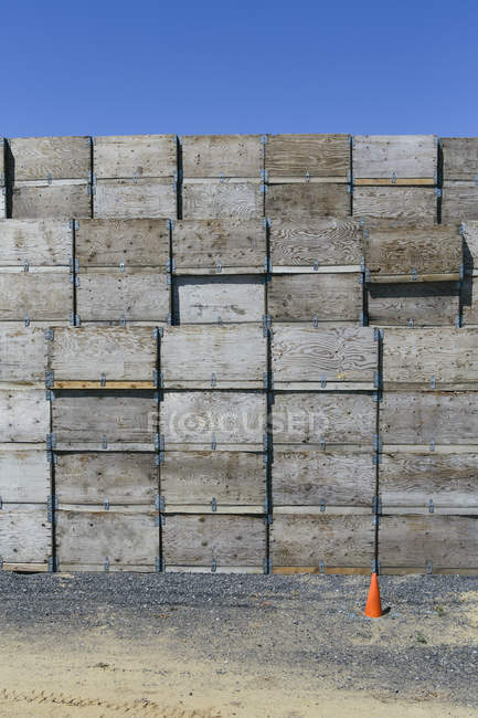 Gran pila de cajas de madera con cono de tráfico en el campo . - foto de stock