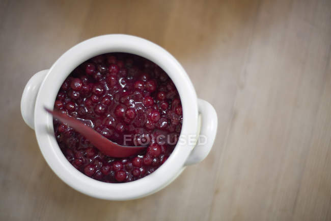 White bowl of fresh cranberries in sauce with matching spoon. — Stock Photo