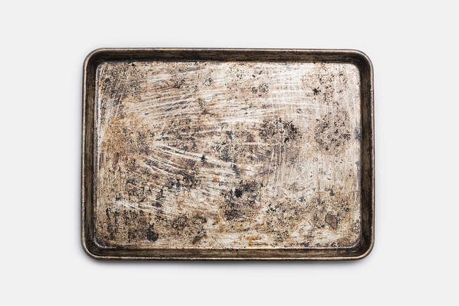 Well used seasoned baking tray on white background — Stock Photo