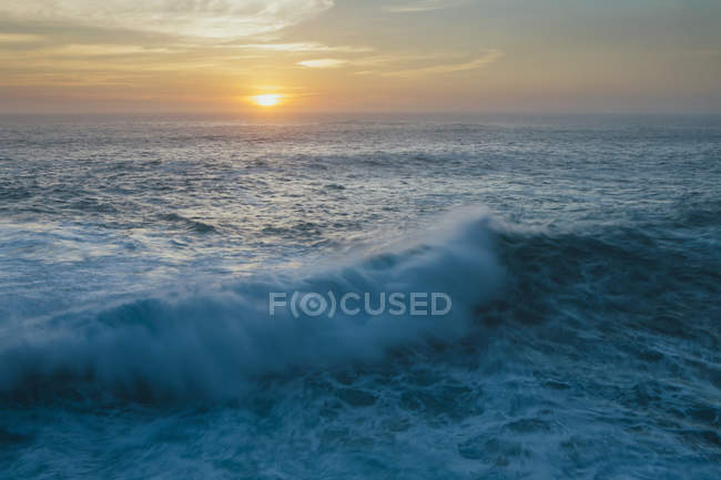 Sonnenuntergang über Horizont über krachenden Wellen und Brandung. — Stockfoto