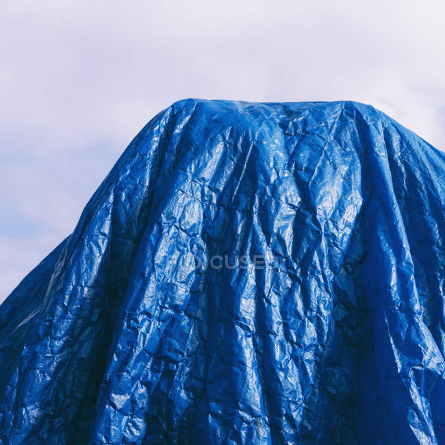 Синій Брезент драпіровані проти синього неба, кадроване. — стокове фото