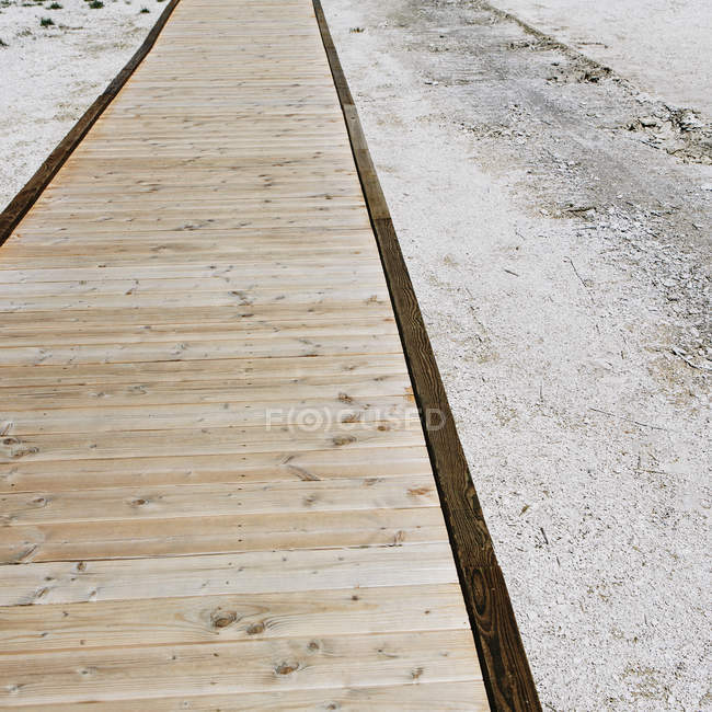 Wooden boardwalk extending across Midway Geyser in Yellowstone National Park. — Stock Photo