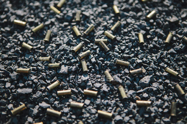 Discarded bullet casings on ground, full frame. — Stock Photo