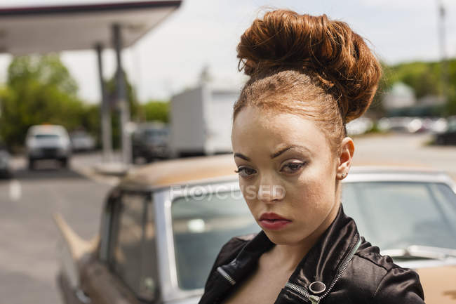 Mulher jovem em maquiagem e expressão severa em jaqueta de couro na rua da cidade . — Fotografia de Stock