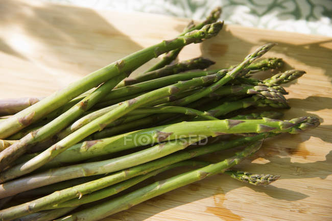 Mazzo di asparagi biologici appena raccolti sul tagliere con coltello da cucina affilato . — Foto stock
