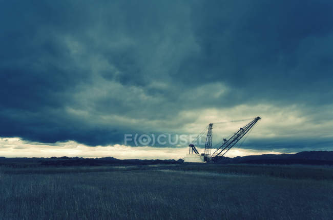 Three tall metal towers silhouetted against sky at drill site. — Stock Photo
