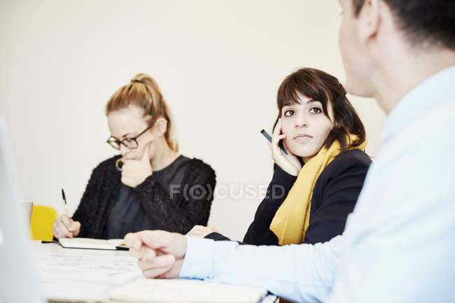 Colaboradores sentados en reunión de negocios alrededor de la mesa . - foto de stock