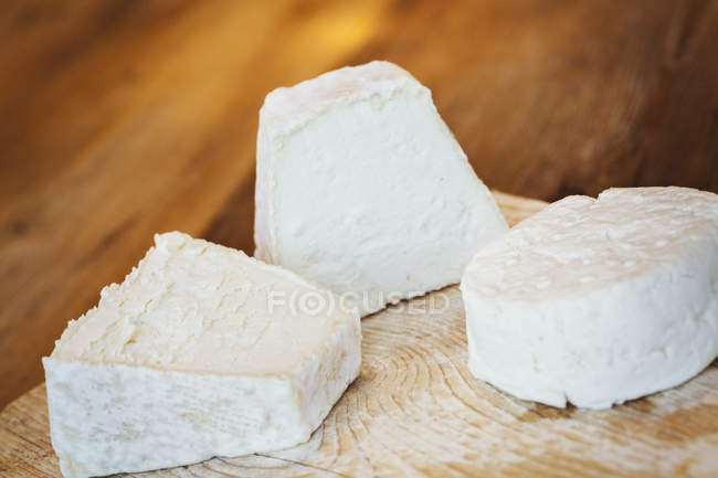 Primer plano del queso fresco de cabra en la tabla de picar . - foto de stock